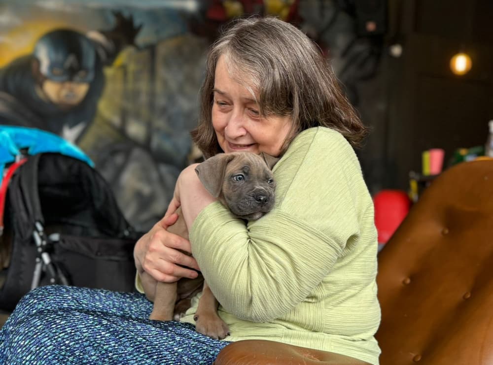 Lady cuddling a puppy