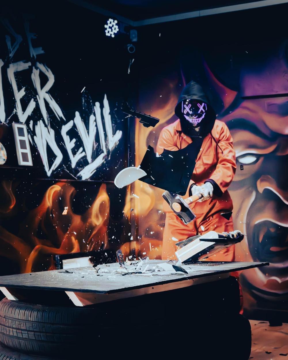 Person smashing tv on a rage room experience