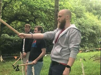 man preparing to throw an axe at the target on an axe throwing experience day