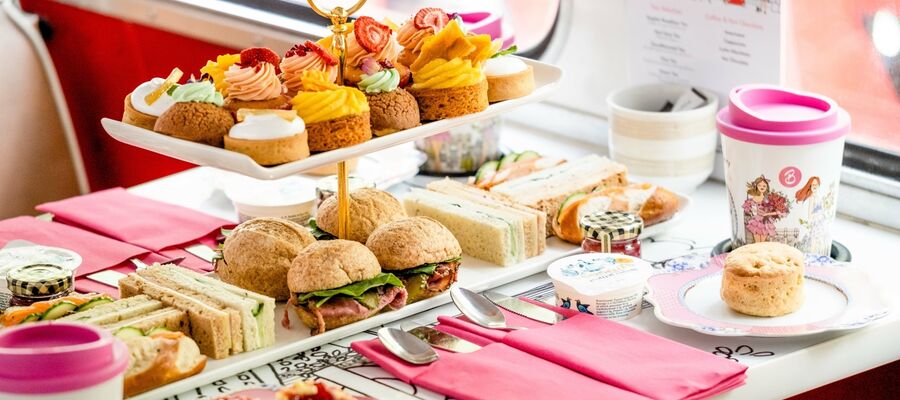 afternoon tea spread of cakes and sandwiches on an afternoon tea bus tour in london