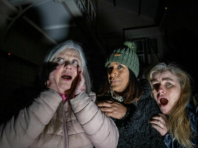 three women looking scared on a ghost tour at a haunted prison experience day