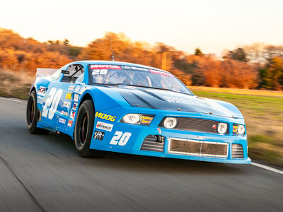 a mustang "late model nascar" on a race track at a gt race car driving experience
