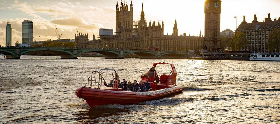 a thames rockets speedboat on the river thames in the evening with the sun setting behind the houses of parliament