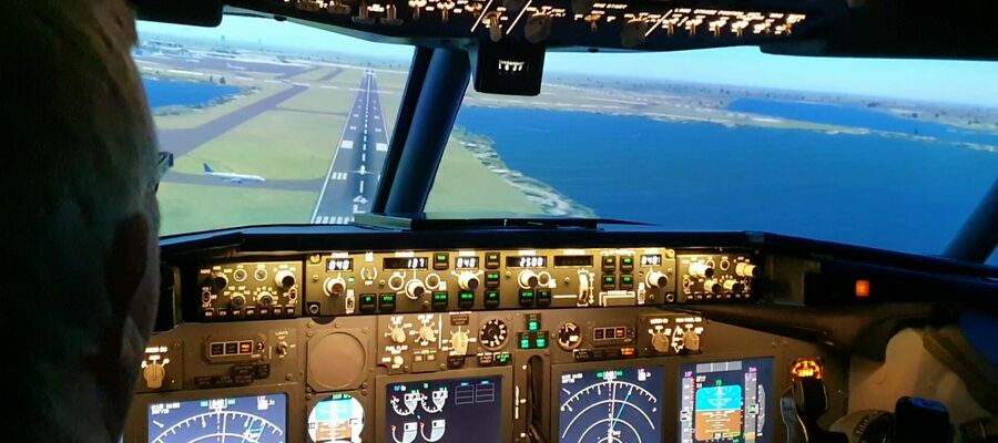 the cockpit of a boeing7371 flight simulator and the view of the runway