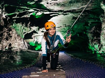 person making their way through an underground cavern experience day at zip world