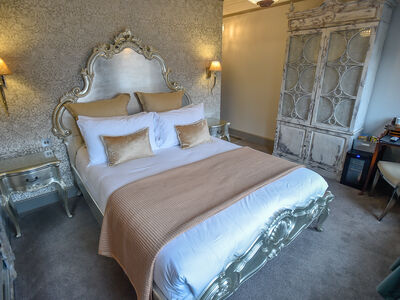 a grand hotel room decorated in tones of silver and champagne for a two night getaway
