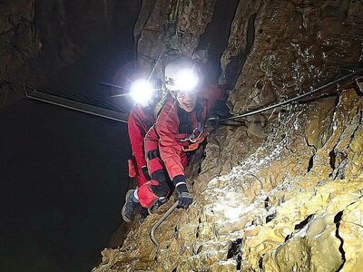 A man and woman enjoying an underground caving experience.