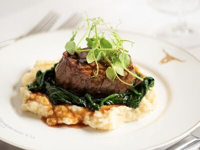 a meal at marco pierre white's london steakhouse company of steak on a layer of mashed potato and vegetables