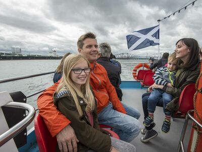 people sitting on the deck of a cruise boat on a daytime sightseeing cruise in scotland