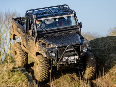 a mad max inspired land rover driving off road down a hill on a driving experience day