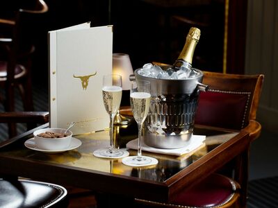 a champagne bucket with two glasses of champagne on a table with a menu