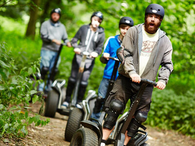 group of people riding through woodland on a segway thrill rally experience day