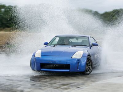 blue sports car drifting through water