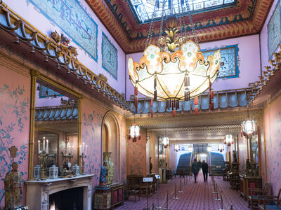 the inside of the long gallery in the royal pavilion brighton, a very grand room with ornate furniture and chandelier