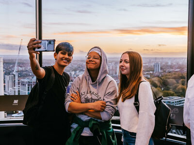 3 visitors taking a selfie at the top of lift 109 overlooking london at the battersea power station