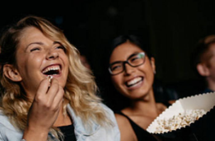 people laughing enjoying a film at the cinema with a cinema pass for up to six people