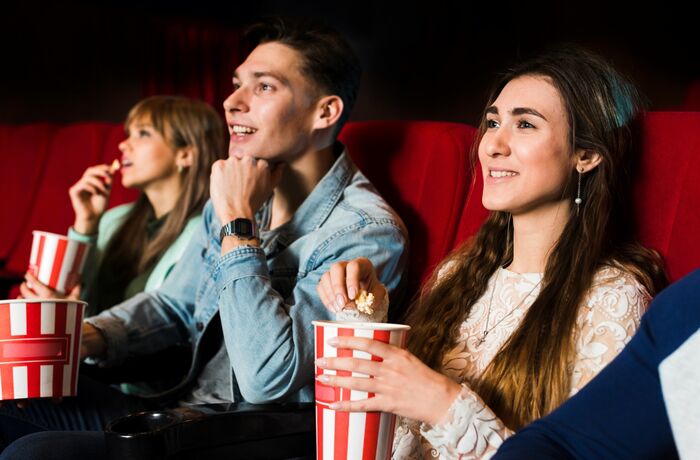 people watching a film and eating popcorn at the cinema with a cinema pass for up to six people